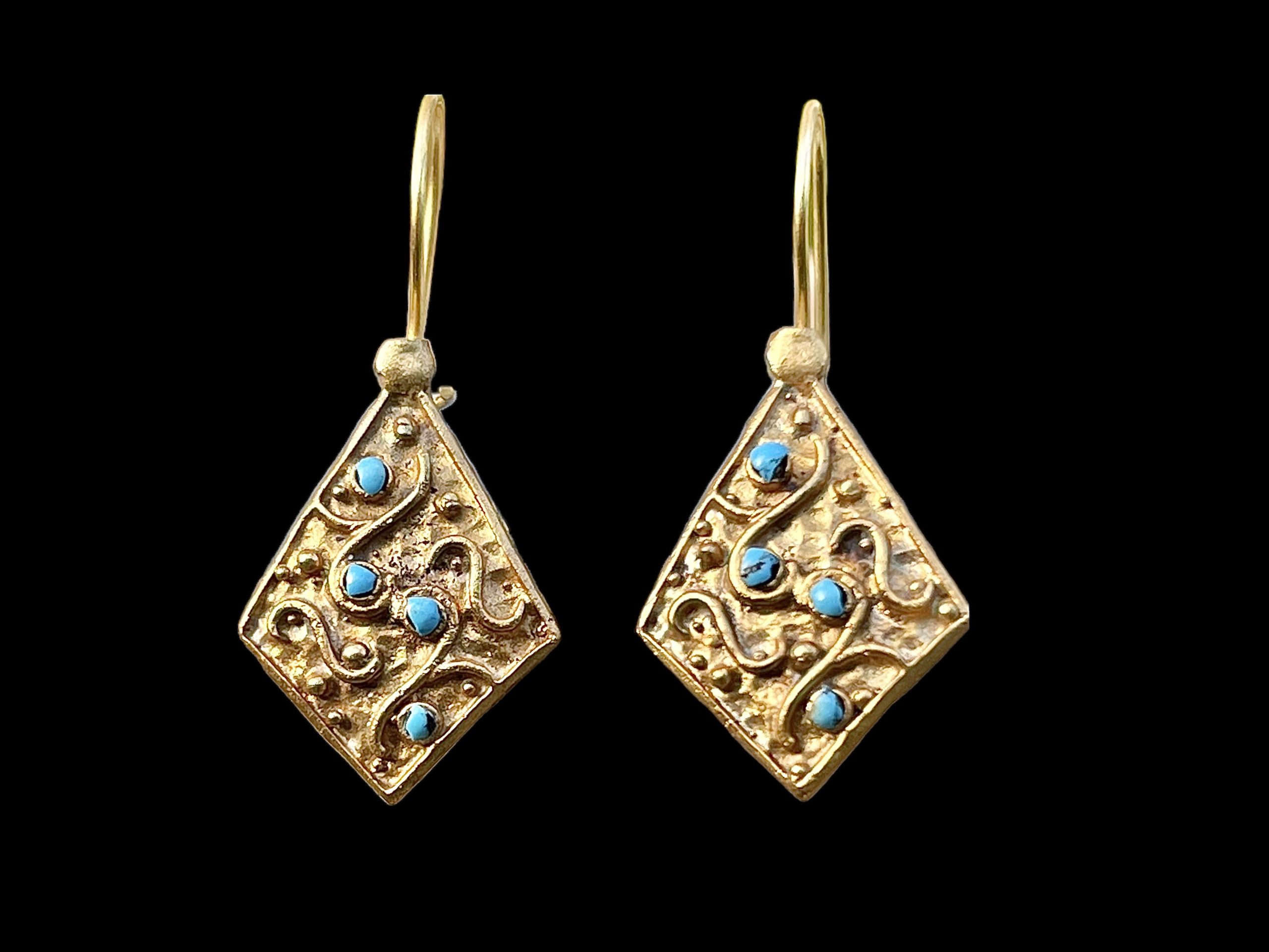 A Pair Of Gold Plated Diamond Shaped Floral Patterned Earrings, Each Inlaid With Four Small Round Turquoise Beads.