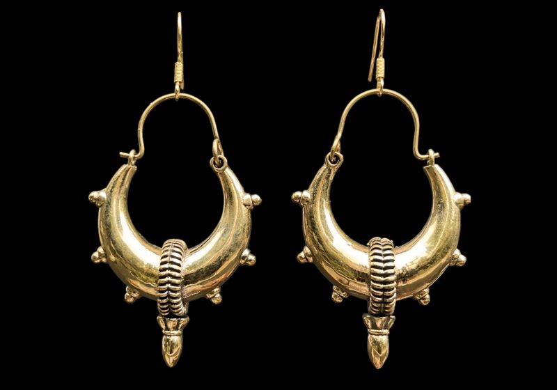 A Pair Of Large Golden Metal Tapered Hoop Earrings Each With Studs And An Oval Pendant