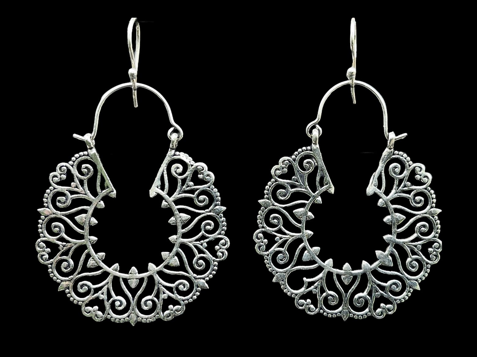 A Pair Of Balinese Large Silver Plated Hoop Earrings With Floral And Heart Shaped Patterned Bands