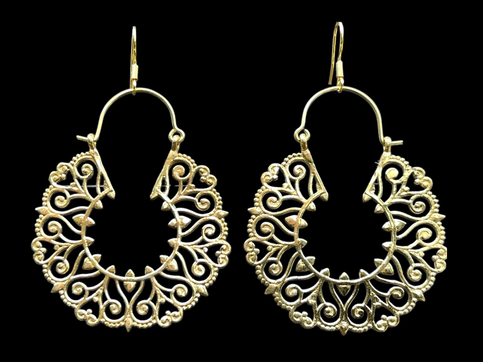 A Pair Of Balinese Brass Hoop Earrings With Floral And Heart Shaped Patterned Bands