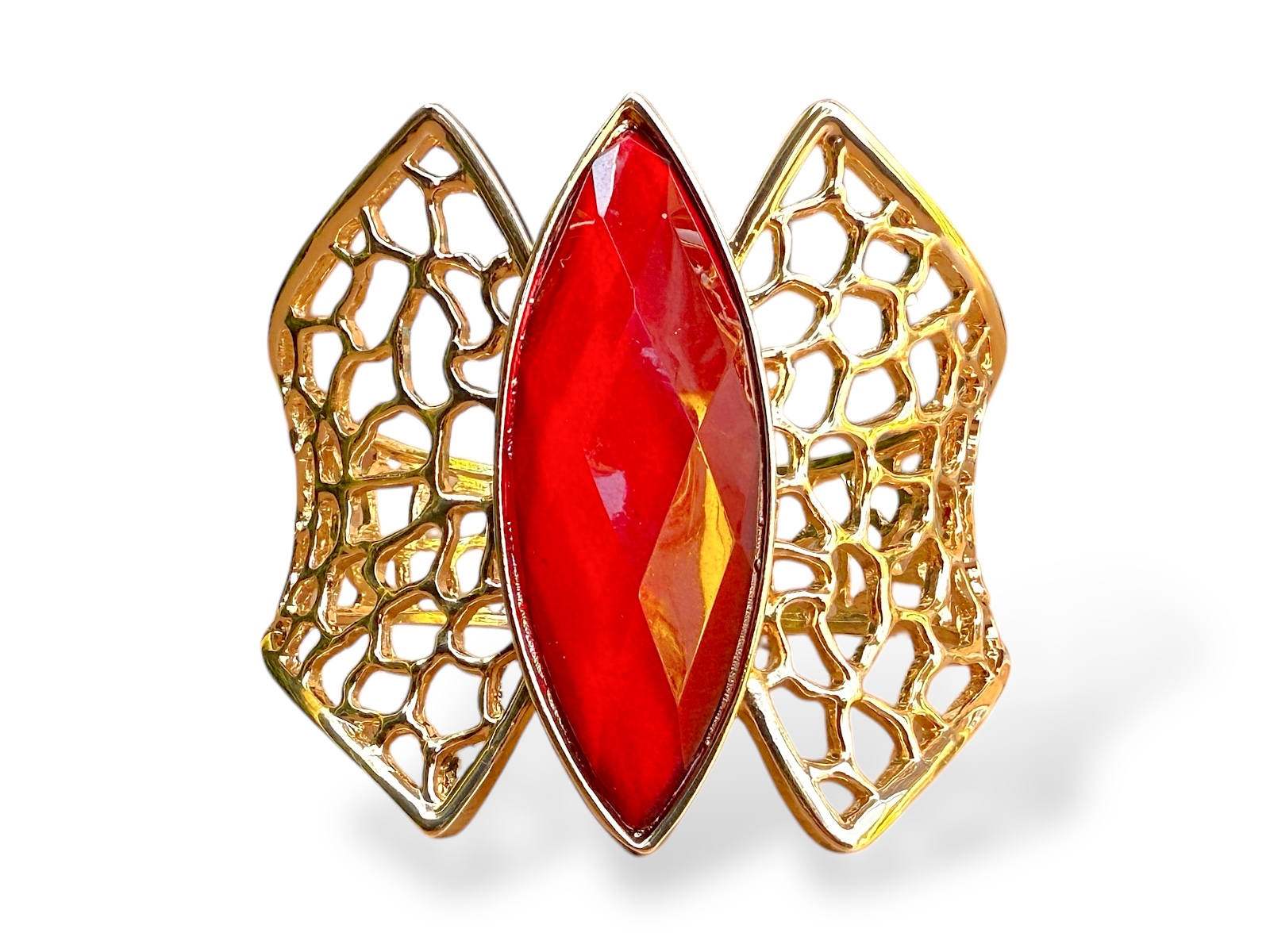 A Golden Metal Filigree Patterned Tapered Bands Hinged Bangle With A Red Facetted Glass Domed Pointed Oval Centre.