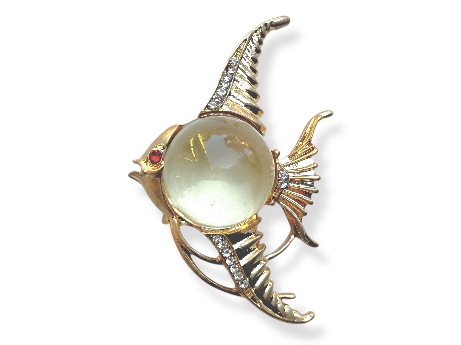 A Golden Metal Brooch Of A Fish With A Clear Resin Domed Circular Body, And Patterned Fins And Tail.