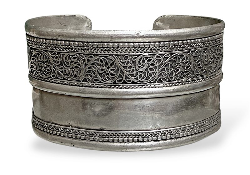 A Nepalese Silver Plated Open Cuff Divided Into A Floral Patterned Band And A Plain Band.