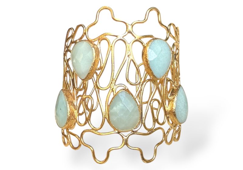 A Gold Plated Open Cuff Of Curved Bands, Inlaid With Five Light Blue Facetted Glass Teardrops, Each Set In A Gold Plated Frame.