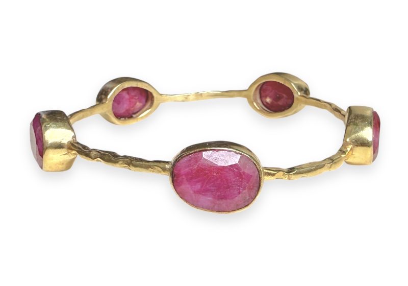 A Gold Plated Narrow Band Bangle, Decorated With Five Ruby Facetted Oval Cabochons.