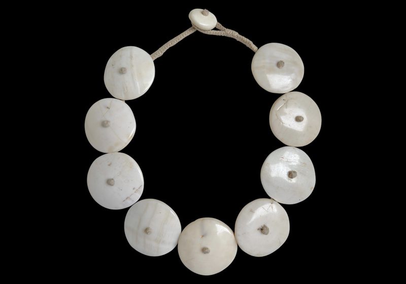 A Naga Vintage Necklace Of Nine Large White Circular Conch Shells On A Beige Braided Cotton Band.