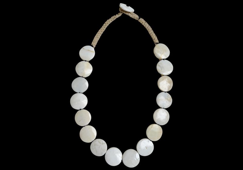 A Naga Long Vintage Necklace Of Sixteen White Circular Conch Shells On A Beige Cotton Band.