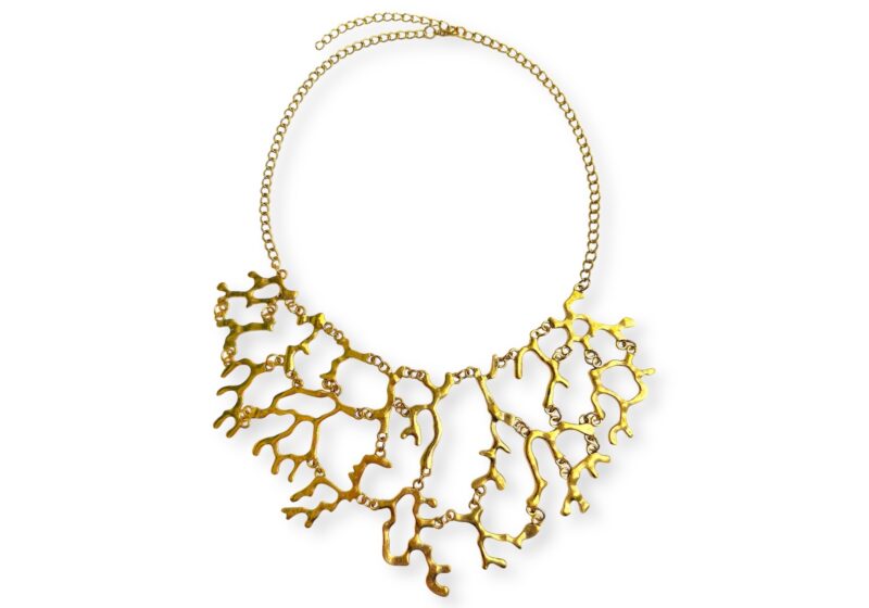A Golden Metal Chain Necklace With A CurvedAnd Tapered Panel Of Linked, Mixed Shaped And Sized, Matt Golden Metal Branches.