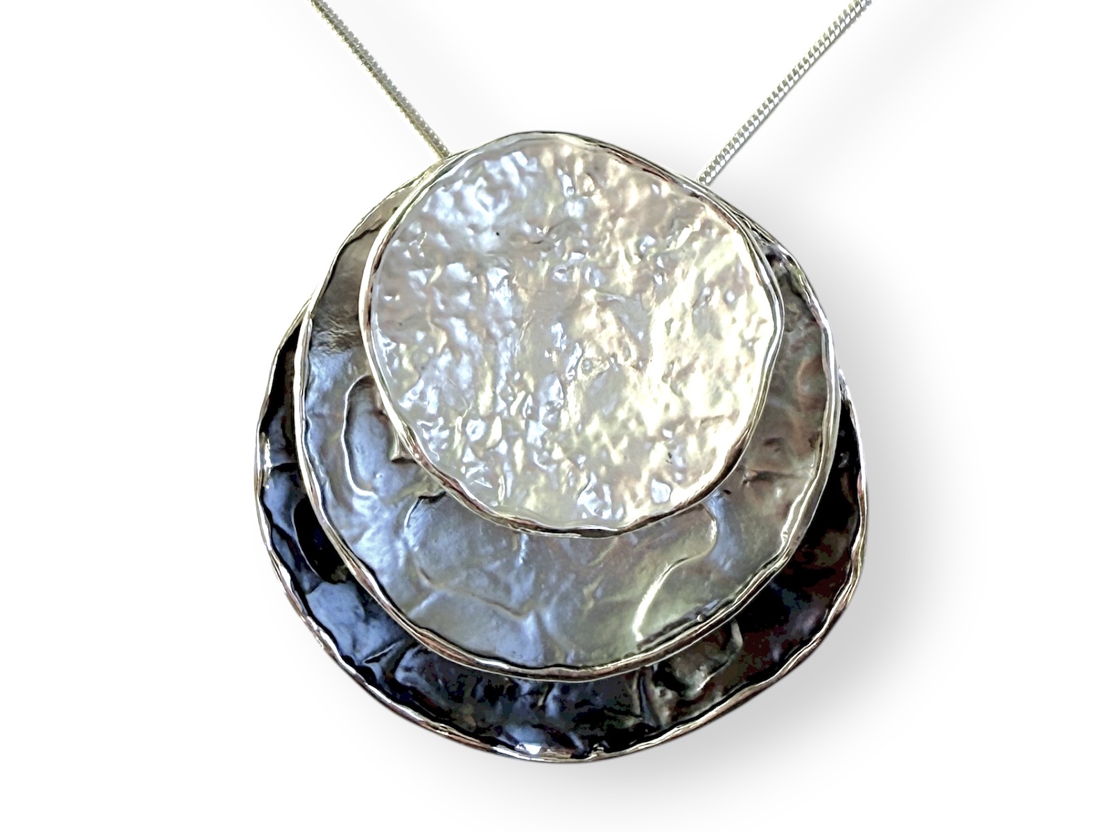 A Silver Plated Pendant Of Three Circular White, Grey, And Black Enamelled Overlapping Discs On A Silver Plated BandNecklace.