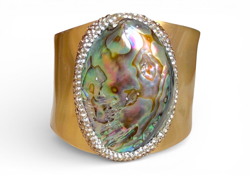 A Matt Golden Metal Hinged Oval Bangle With An Abalone Shell Centre With Clear And Gold Rows Of Faceted Glass Border