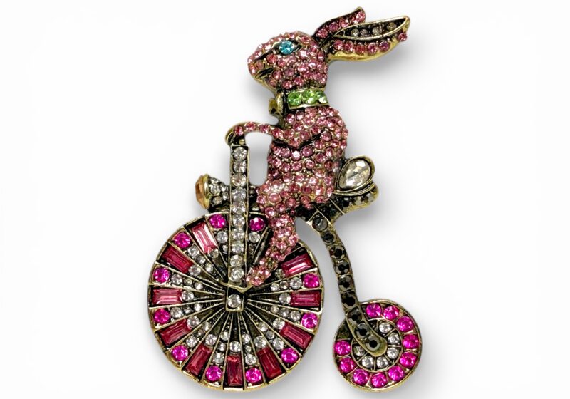 Golden Metal Brooch Of A Rabbit Riding A Bicycle Inlaid With Facetted Pink Cabochons