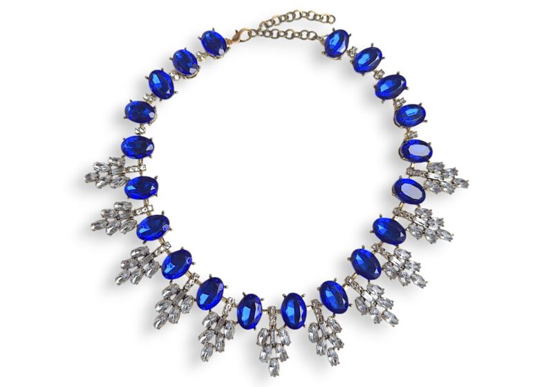 A Golden Metal Necklace With Blue And Clear Facetted Resin Cabochons.