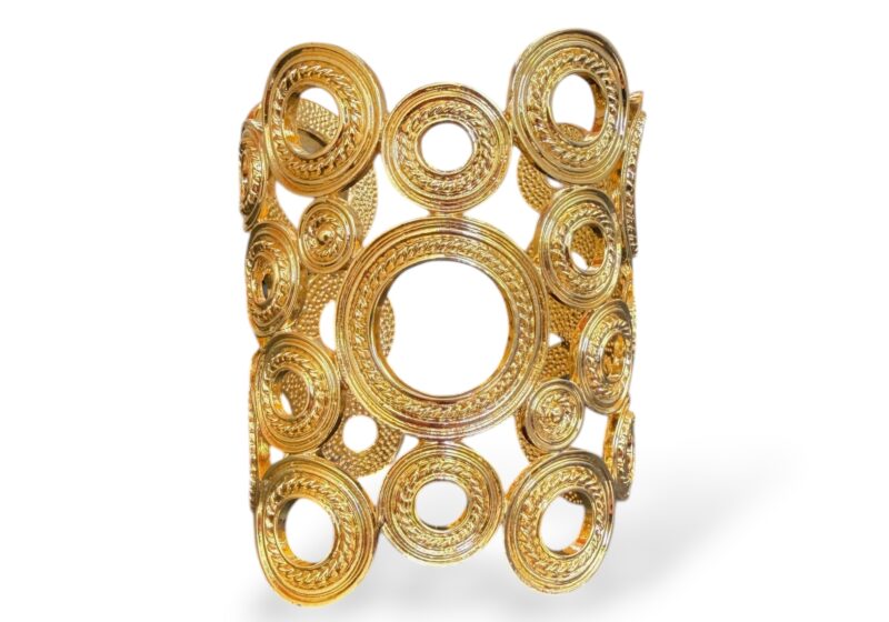 A Long Golden Metal Open Cuff Of Twenty-Eight, Mixed Sized, Patterned Circular Bands.