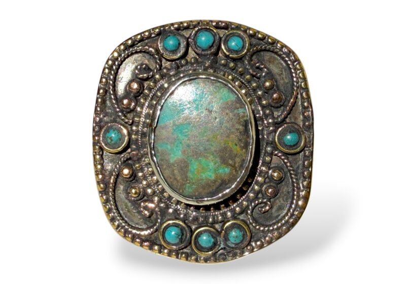 A Turkmen Silver Plated And Brass Large Oval Top Patterned Ring Inlaid With One Large And Eight Small Turquoise Cabochons.