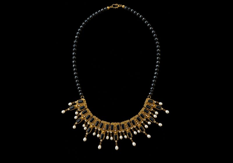 A Necklace Of Black Facetted Round Glass Beads With Golden Metal Pendants Inlaid With Blue Facetted Glass Rectangles And White Freshwater Pearls.