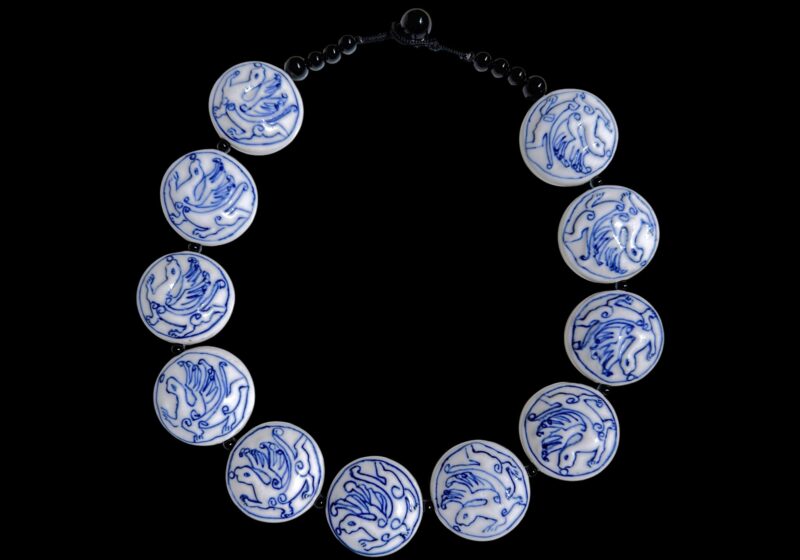 A Necklace Of Eleven Blue And White Porcelain Domed Circular 'Dragon' Beads, With Black Onyx Round Beads.