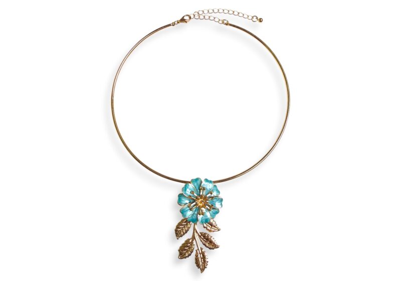 A Golden Metal Torque Necklace With A Pendant Of A Blue Enamelled Flower And Golden Metal Leaves.