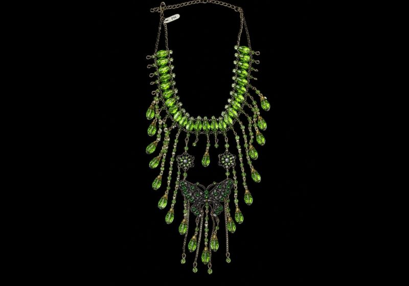 A Necklace Of Golden Metal Chains And Green Facetted Oval Glass Beads And A Butterfly.