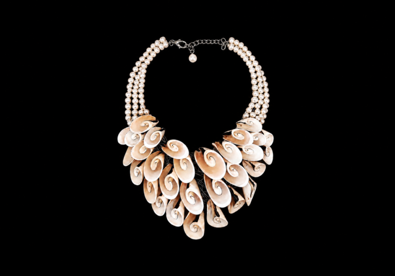 A Four Strand Necklace Of White Freshwater Pearls, And A Curved Tapered Three Row Panel Of Curved And Coiled Light Brown Shell Oval Slices.