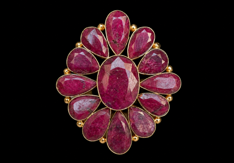 A Large Gold Plated Floral Patterned Ring With Twelve Facetted Ruby Teardrop Shaped Cabochons, And One Facetted Oval Shaped Cabochon, Each Set In A Gold Plated Frame.