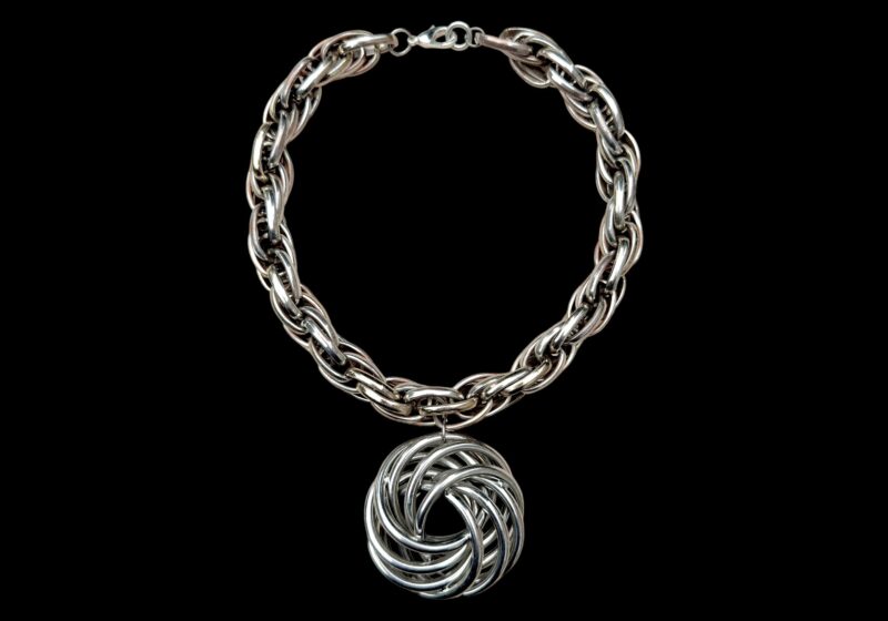 A Necklace Of Golden And Silvered MetaI Interlocking Oval Bands, With A Circular Pendant Of Interlocking Rings.