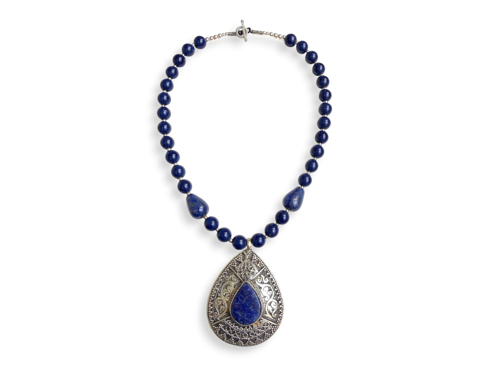 An Afghan Necklace Of Lapis Lazuli Round Beads And Small Silver Plated Round Spacers, Lapis Beaded Necklace With An Afghan Silver Plated Patterned Teardrop Shaped Pendant With A Lapis Lazuli Teardrop Shaped Cabochon.
