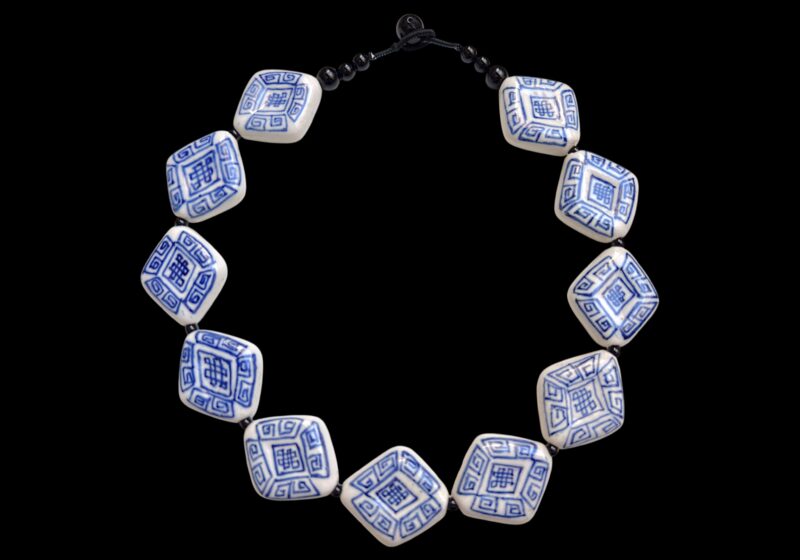 A Necklace Of Eleven Blue And White Patterned Porcelain Diamond Shaped Beads With Black Onyx Round Beads And Spacers.