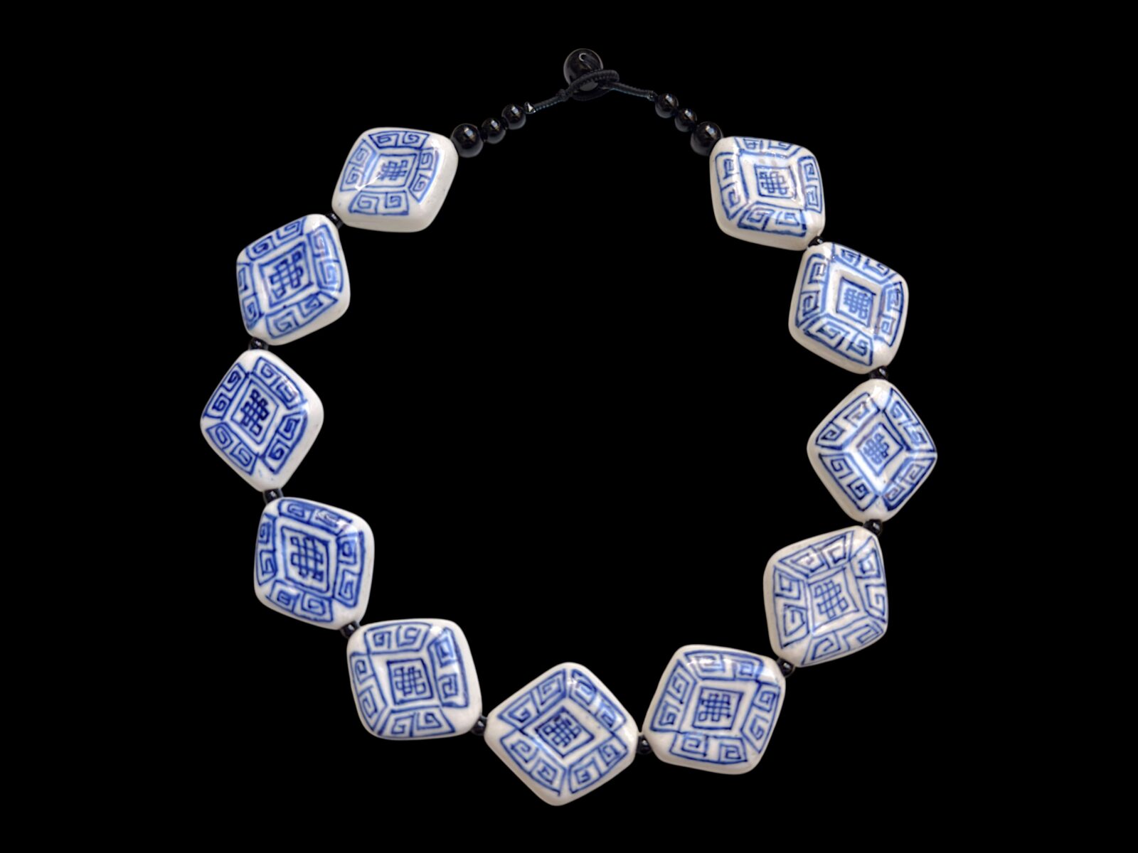 A Necklace Of Eleven Blue And White Patterned Porcelain Diamond Shaped Beads With Black Onyx Round Beads And Spacers.