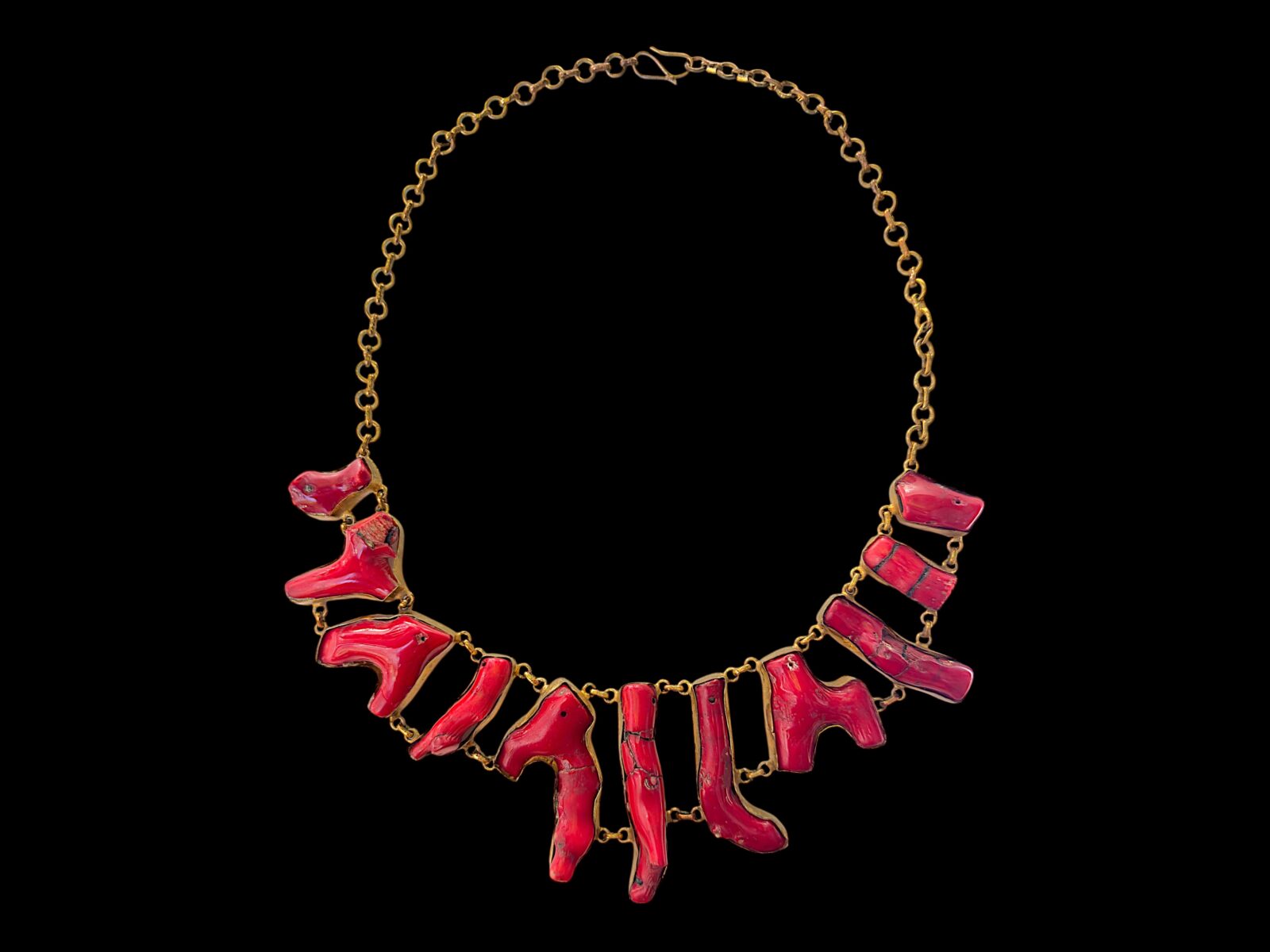 A Golden Metal Chain Necklace With Linked Red Dyed Sea Bamboo Coral Irregular Shaped Branches, Each Set In A Golden Metal Frame.