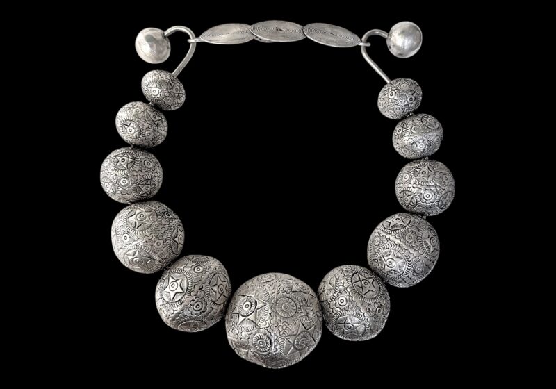 A Miao Vintage Circular Band Necklace Of Eleven Graduated Large Patterned Round Hollow Silver Plated Beads. China.