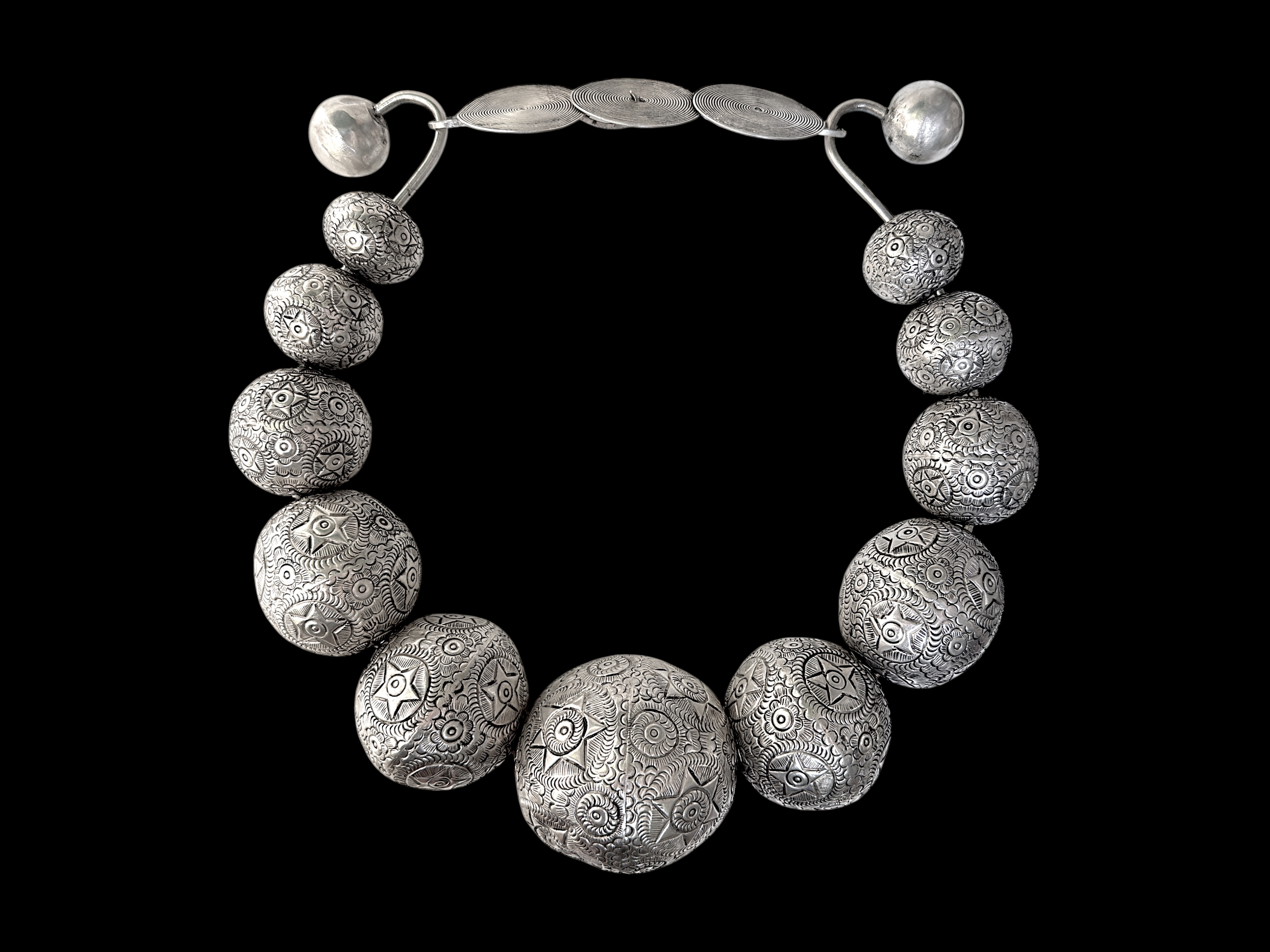 A Miao Vintage Circular Band Necklace Of Eleven Graduated Large Patterned Round Hollow Silver Plated Beads. China.