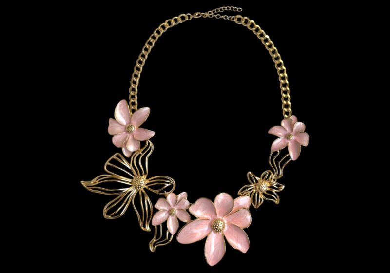 A Golden Metal Chain Necklace With Four Pink Enamelled Magnolia Flowers And Two Golden Metal Bands Magnolia Flowers.