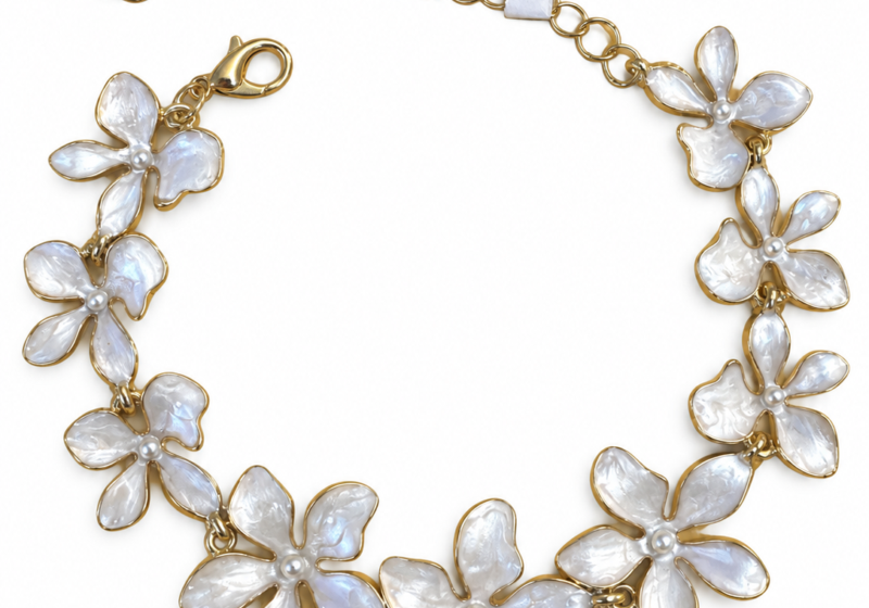 A Golden Metal Bracelet With White Enamel Painted Flowers.