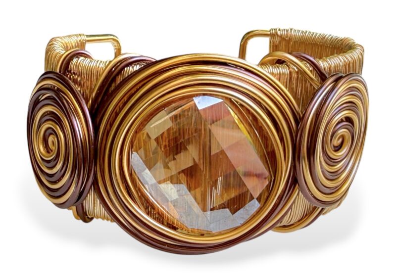 A Golden Metal Wire Strands Open Cuff With Coiled Bands Of Golden And Brown Wire With A Facetted Amber Glass Bead Centre